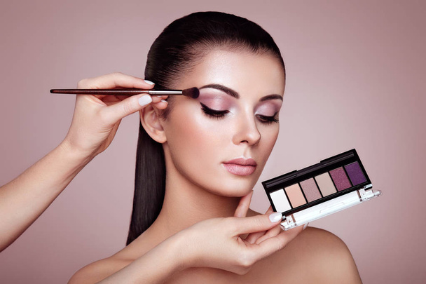 Makeup artist applies eye shadow - Fotó, kép