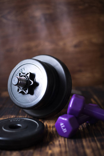 Dumbbells on a wooden dark background. Concept of playing sports - Foto, imagen