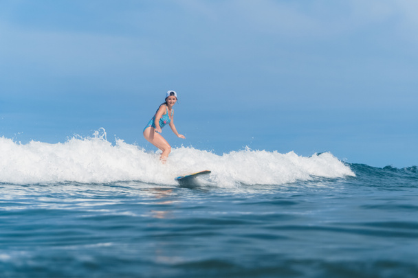 woman in swimming suit surfing in ocean - Photo, Image