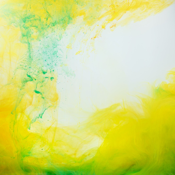 abstract background with green and yellow paint flowing in water - Foto, imagen
