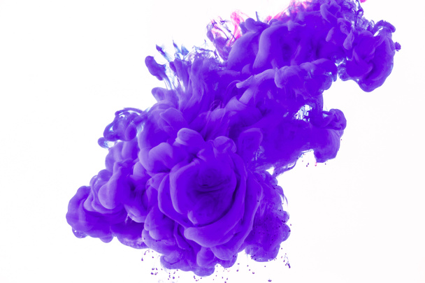 creative design with flowing purple paint in water, isolated on white - Фото, изображение