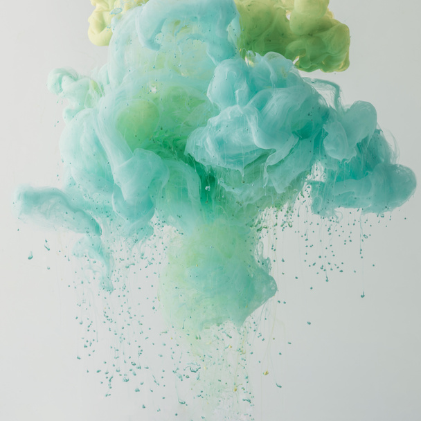 artistieke achtergrond met turquoise verf stroomt in water, geïsoleerd op grijs - Foto, afbeelding