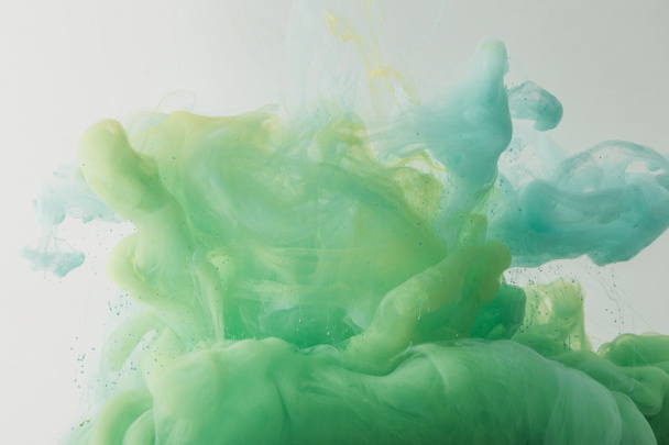 Lekka tekstura z płynącej turkus i zielonej farby w wodzie, na szarym tle - Zdjęcie, obraz