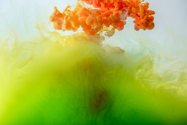 acrylic background with mixing green, yellow and orange paint in water - Foto, Bild