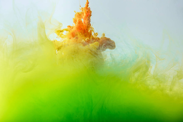 künstlerische Tapete mit fließender grüner und orangefarbener Rauchfarbe - Foto, Bild