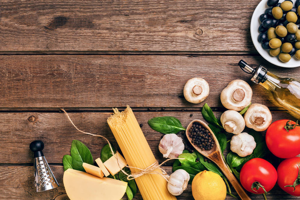 パスタの食材 - トマト、オリーブ オイル、ニンニク、イタリアン ハーブ、新鮮なバジル、塩とコピー スペースを持つ木製の背景にスパゲッティ、水平、トップ ビュー - 写真・画像