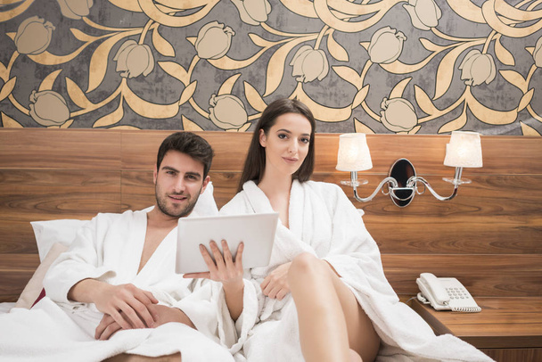 Beautiful happy young couple enjoying in bed after spa. Couple i - Fotoğraf, Görsel
