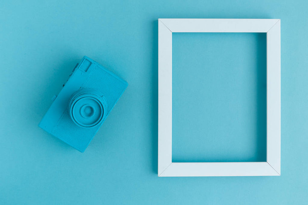 Flat lay of blue vintage camera and photo frame background - Φωτογραφία, εικόνα