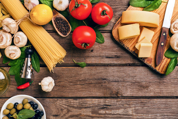 Olasz étel főzés-paradicsom, bazsalikom, tészta, olívaolaj és sajtot fa háttér, felülnézet, másolja a hely. - Fotó, kép