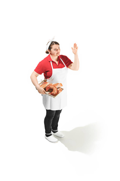 Portrait of cute smiling woman with pastries in her hands in the studio, isolated on white background - Fotó, kép