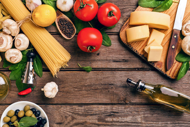 イタリア料理クッキング トマト、バジル、パスタ、オリーブ オイル、チーズの木製の背景、トップ ビュー コピー スペース. - 写真・画像