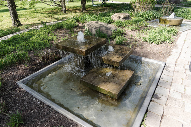 Pequena fonte com água no parque
 - Foto, Imagem