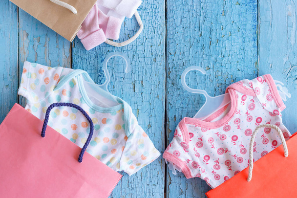 Different clothes for a newborn and paper packages - Φωτογραφία, εικόνα
