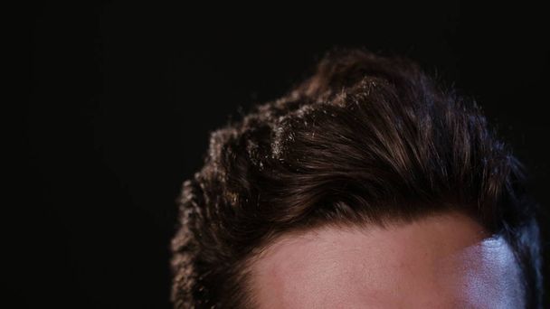 Man Touching his Hair Against a Black Background - Photo, image