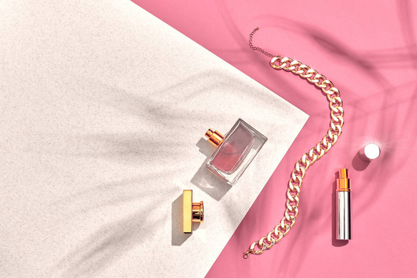 Moda Womens Cosméticos e Acessórios. Flat Lay. Perfume. Fundo rosa e branco. Sombra de uma folha de palma
 - Foto, Imagem