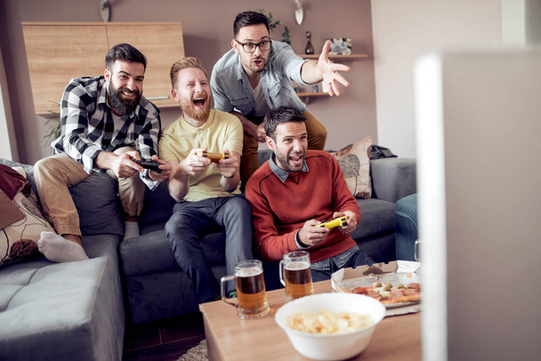 Group of friends playing video games at home. - Foto, Bild