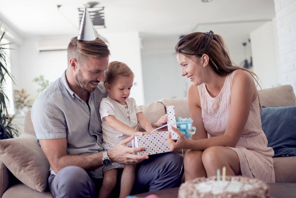 Familie, Kinder, Feier, Feiertage, Geburtstag und glückliche Menschen - glücklicher Vater, Mutter und Sohn öffnen Geschenkbox. - Foto, Bild