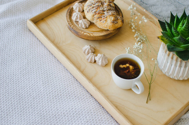 Πρωινό στο κρεβάτι, μυρωδάτο τσάι και κρουασάν για πρωινό - Φωτογραφία, εικόνα