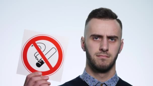 young man holding signs no smoking on a white background - Video, Çekim