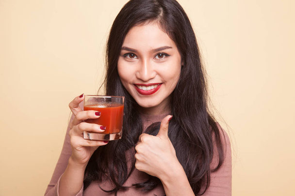 Young Asian woman drink tomato juice. - Foto, afbeelding