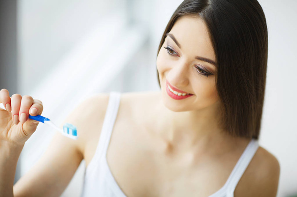 美しい笑顔の女性ブラシで健康な白い歯をブラッシング. - 写真・画像