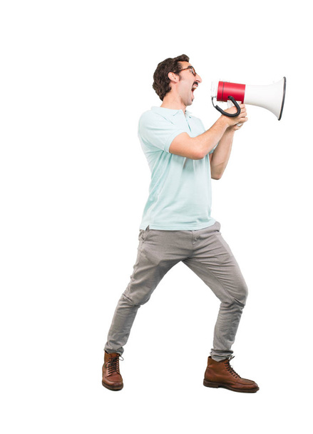 Young crazy man shouting with a megaphone. Full body cutout person against white background. - Foto, Imagem