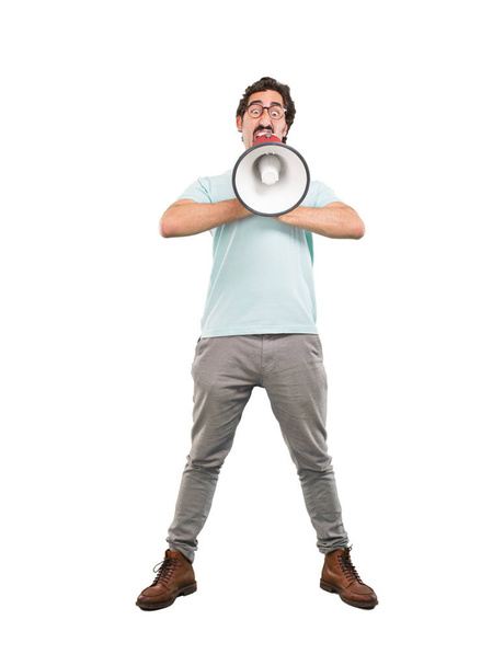 Young crazy man shouting with a megaphone. Full body cutout person against white background. - Photo, Image