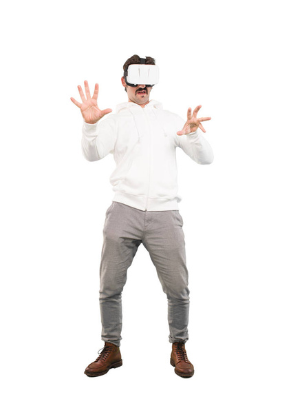 Young crazy man with a virtual reallity glasses. Full body cutout person against white background. - Valokuva, kuva
