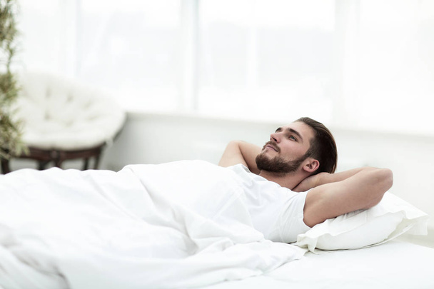 tired man resting on a comfortable bed - Valokuva, kuva