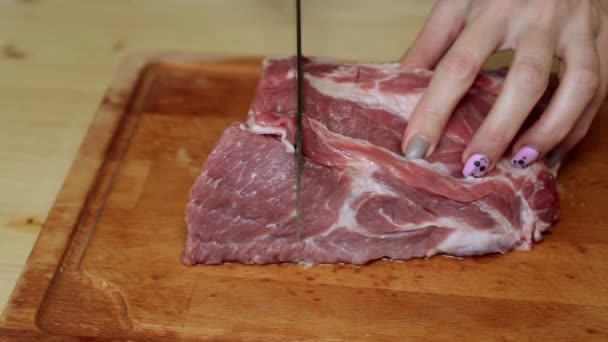Una mujer está cortando carne en la cocina
. - Metraje, vídeo
