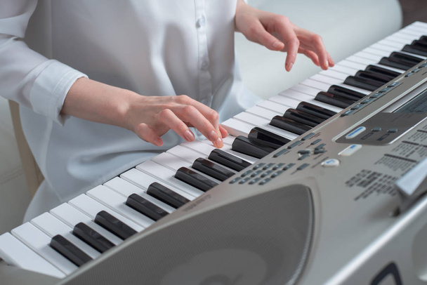 das Konzept, Melodien zu komponieren, die Hände spielen den Synthesizer - Foto, Bild