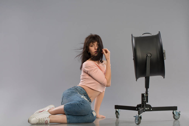 Young sexy female model posing with working fan - Фото, зображення