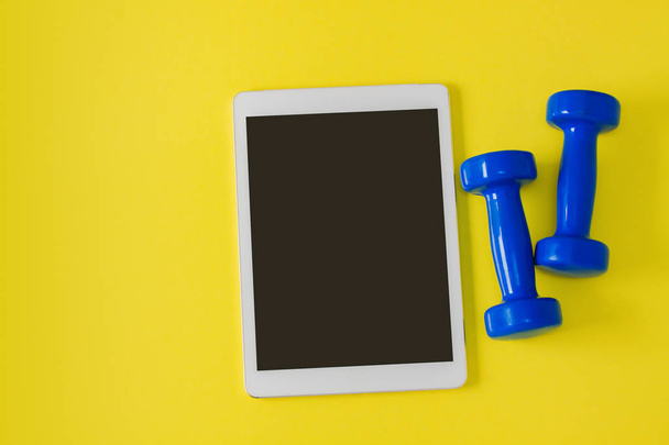 Sport flat lay composition tablet and blue dumbbells - Photo, Image