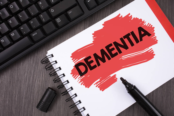 Writing note showing  Dementia. Business photo showcasing Long term memory loss sign and symptoms made me retire sooner written on Painted Notepad on wooden background Keyboard and Marker. - Fotografie, Obrázek