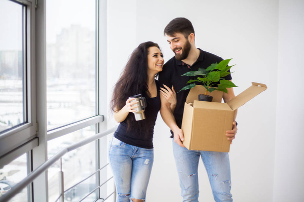 Feliz joven pareja moviéndose en nuevo hogar desembalaje cajas
 - Foto, Imagen