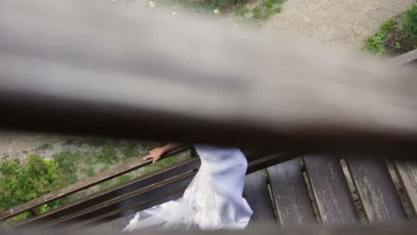 Piękna panna młoda z długim welonem po schodach - Materiał filmowy, wideo