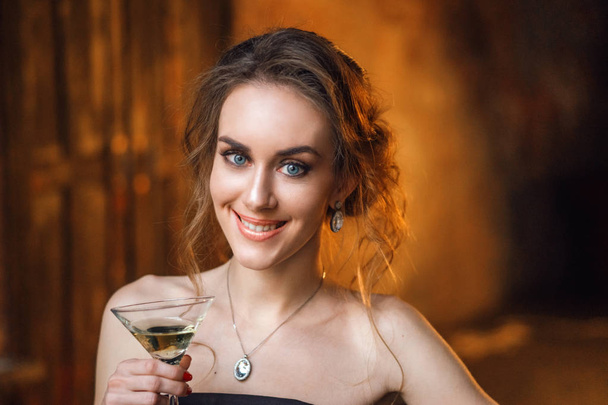 fashion young woman wearing elegant dress posing with drink in studio  - Fotó, kép