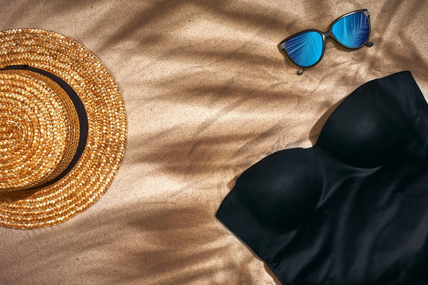 Womens strand accessoires of zomer outfit op zand achtergrond. Bovenaanzicht met kopie ruimte - Foto, afbeelding