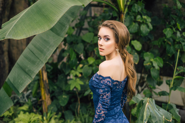 modello donna in posa in giardino indossando abito blu scuro
  - Foto, immagini