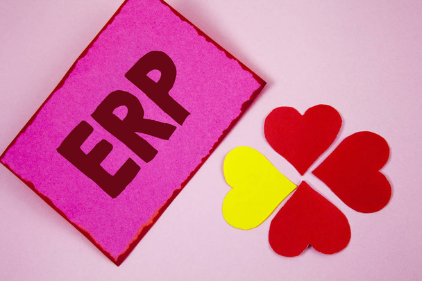 Word pisanie tekstu Erp. Koncepcja biznesowa dla systemów ERP z automatyzowania funkcji back-office na papierze notatki na różowym tle zwykłego papieru serca obok niego. - Zdjęcie, obraz