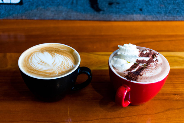 A coffee and hot chocolate sitting on a wooden table - Photo, Image
