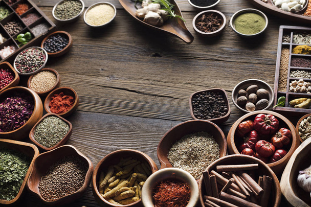 Nutrition theme. Collection of spices in bowls on wooden rustic table. - Photo, Image