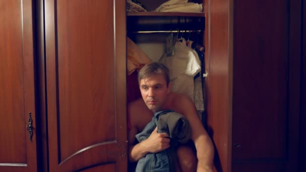the naked man is hiding in the wardrobe. he goes out of the closet and runs away from the mistresss house through the front door. 4k, - Materiał filmowy, wideo