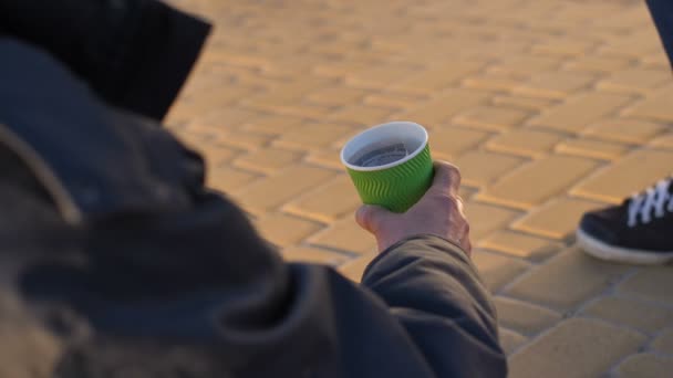 Close-up homeless beggars hand with paper cup - Footage, Video
