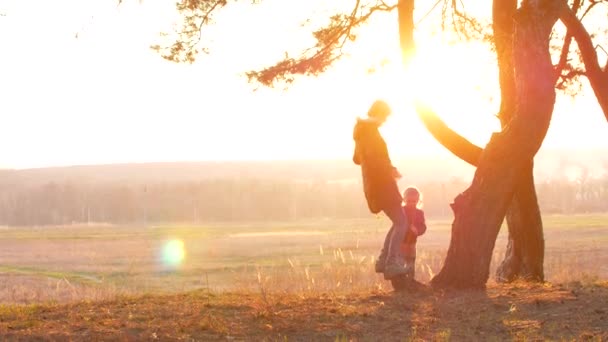 Sylwetki matki i dziecka zachód słońca - Materiał filmowy, wideo