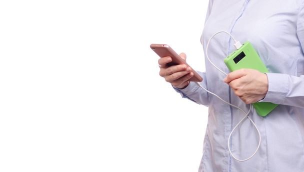 Woman in a shirt in the hands of a mobile phone and a power bank - Photo, Image