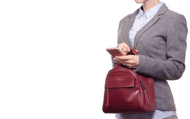 Woman in shirt and jacket is holding a mobile phone and a handbag business - Foto, afbeelding
