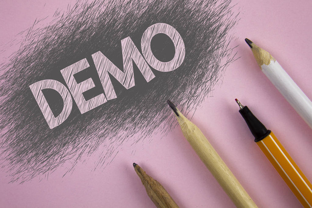 Szöveg jel mutatja Demo. Fogalmi fénykép bemutató szoftver társaságok termékek jelennek meg a rózsaszín háttér toll és ceruza, mellette évente írásos. - Fotó, kép