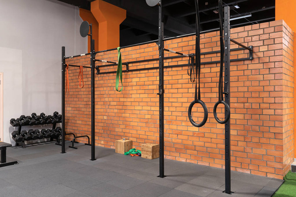 Interior do ginásio para treinamento de fitness com barra horizontal e anéis
 - Foto, Imagem