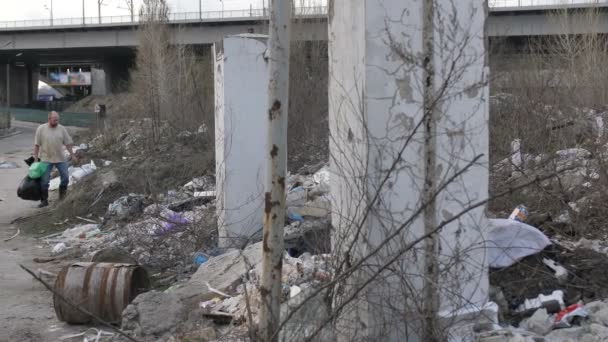 Άνδρας ψάχνει για πλαστικό στο σκουπιδότοπο στην πόλη - Πλάνα, βίντεο